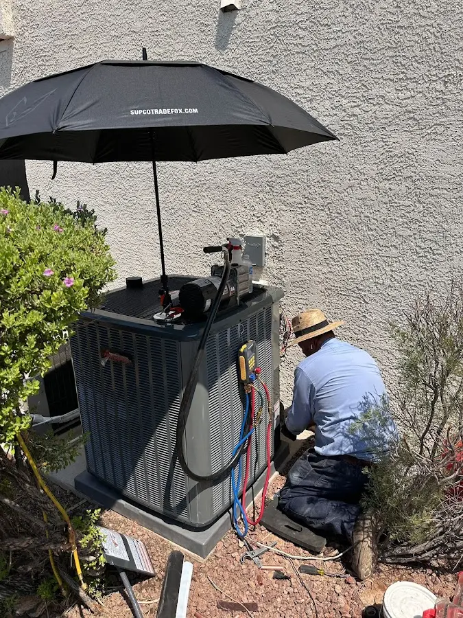 HVAC technician performing outdoor AC maintenance in Holly